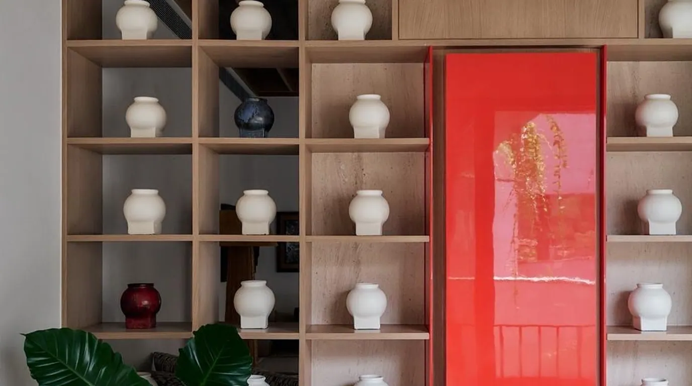 KSHITIJ display shelves with ceramics and red artwork